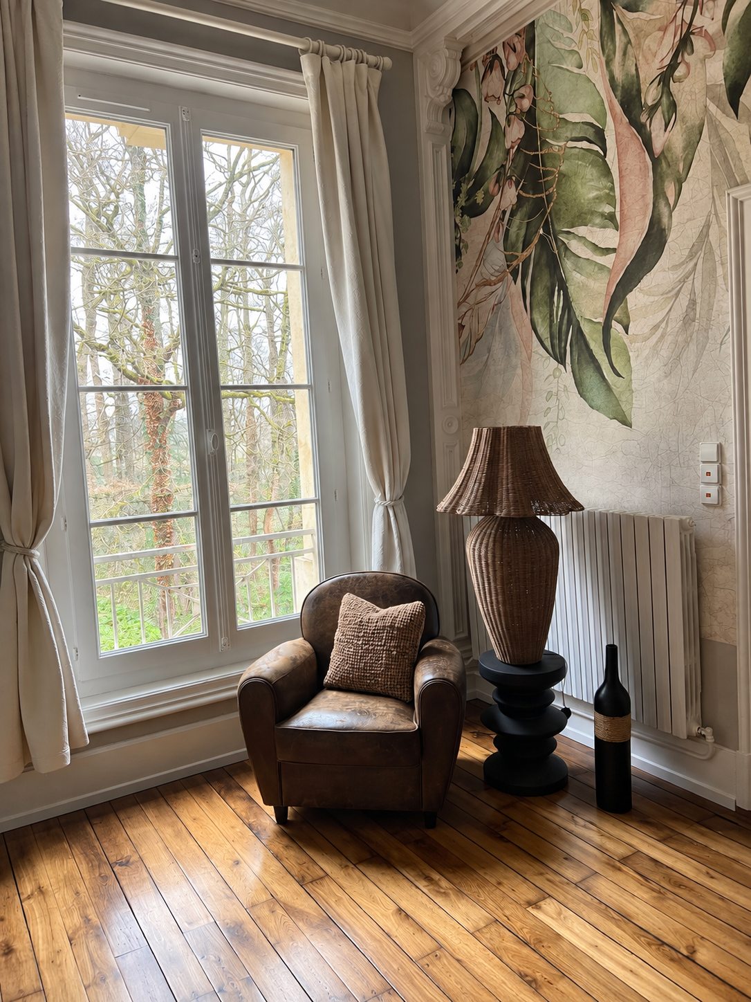 Gemütliche Leseecke mit Ledersessel, großer Fensterfront und botanischer Tapete